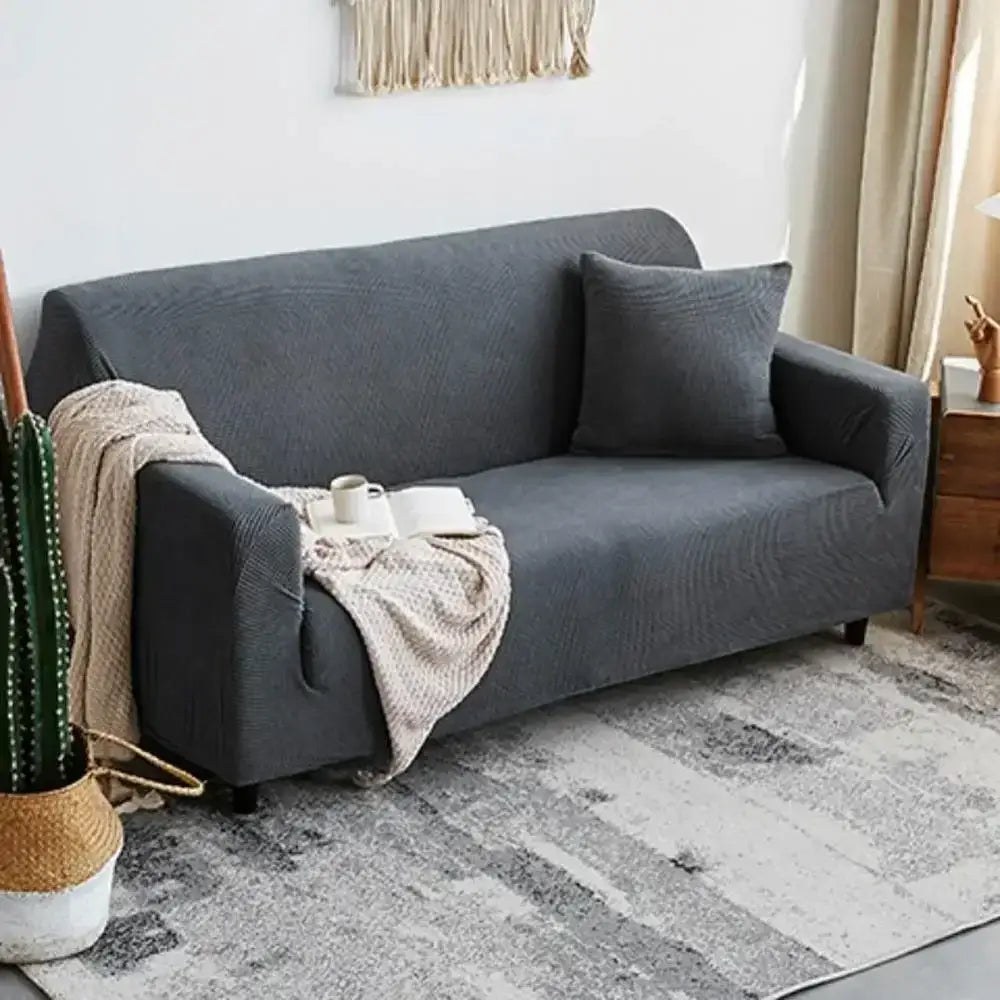 Dark gray textured fabric sofa slipcover with matching pillow and beige knit throw featuring decorbites cozy fleece