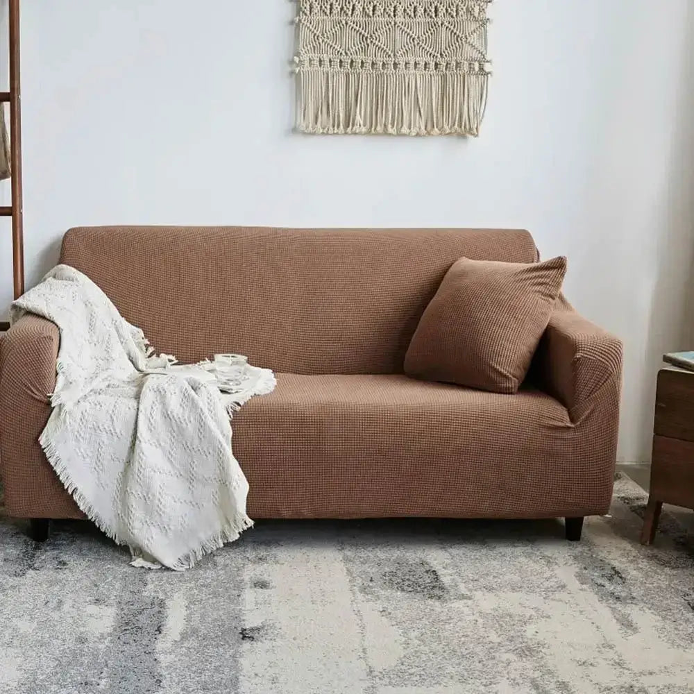 Brown textured sofa slipcover with matching pillow and white knitted throw showcasing decorbites cozy fleece sofa wrap