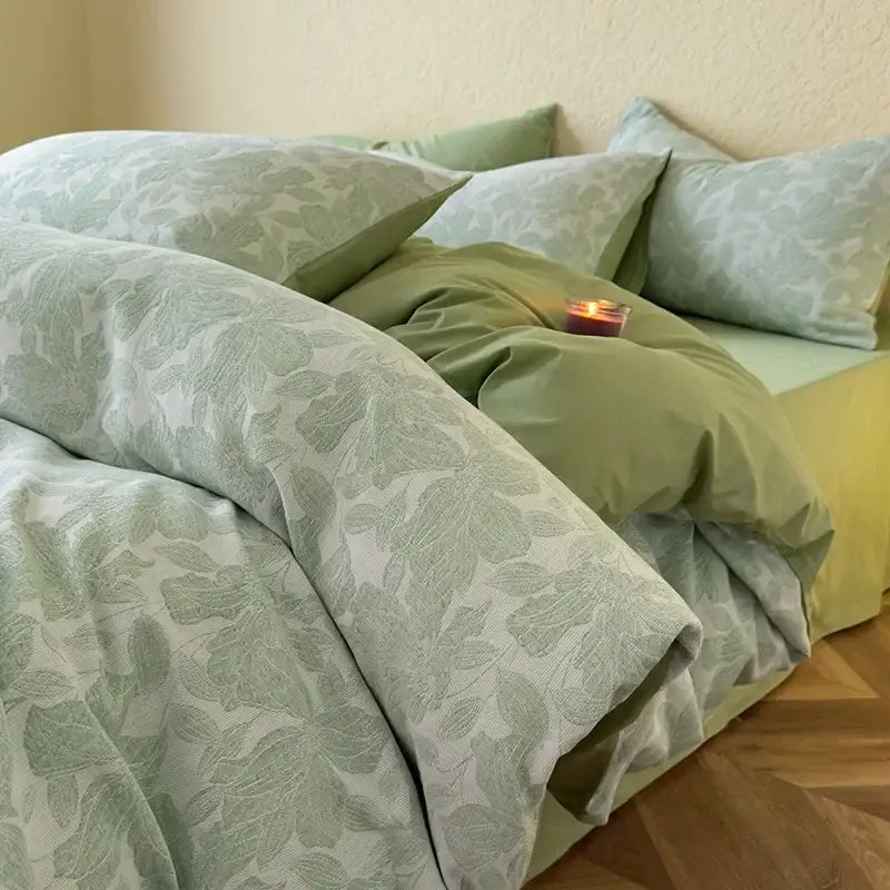 A soft sage green decorbites cotton bedding set with subtle leaf pattern and coordinating pillows and bed skirt
