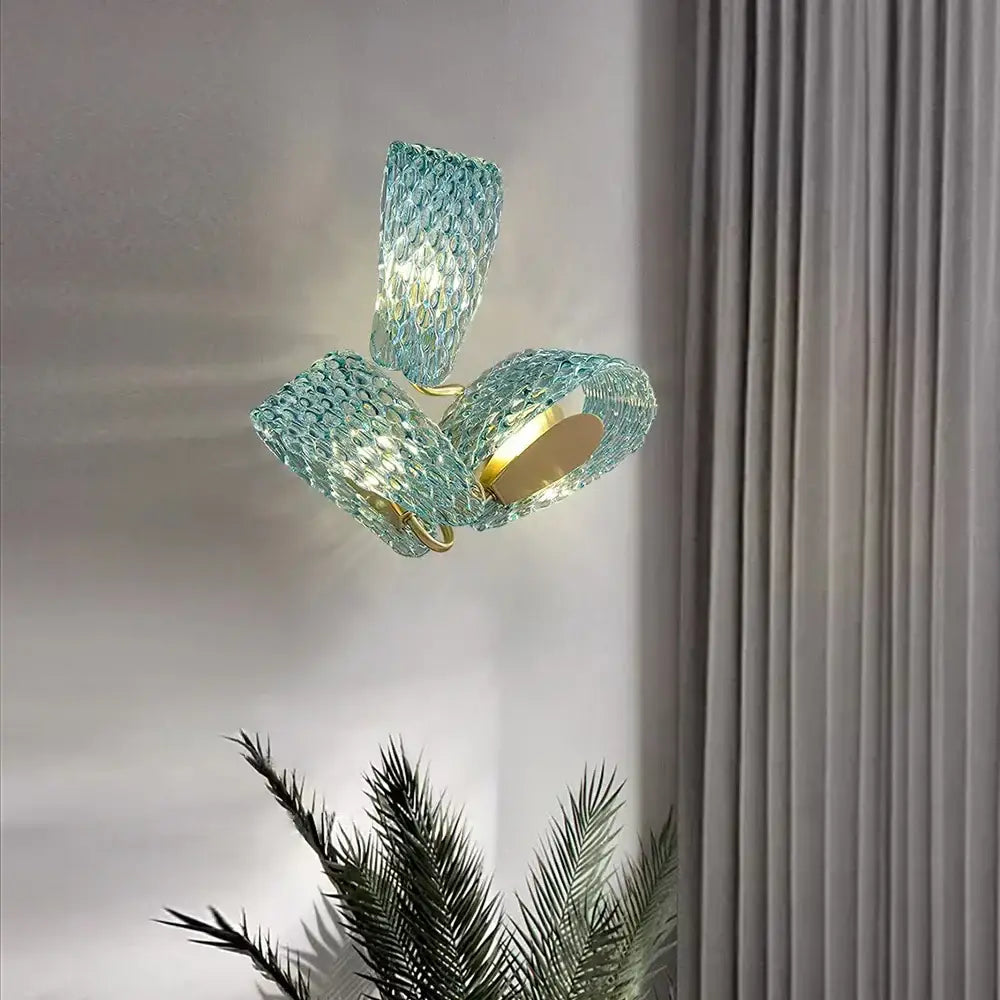 A modern teal textured turquoise blue glass luxury wall sconce with woven design and gold-toned decorbites blue glass accents