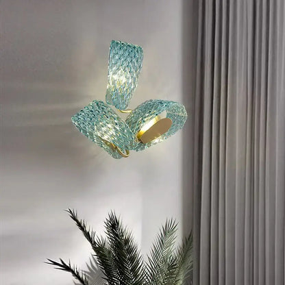 A modern teal textured turquoise blue glass luxury wall sconce with woven design and gold-toned decorbites blue glass accents
