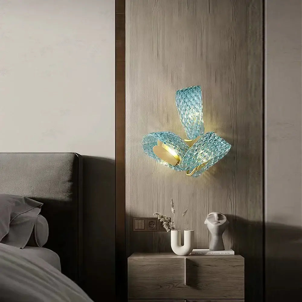 A modern wall sconce with textured turquoise blue glass luxury elements and gold-toned metal for bedroom decorbites blue glass