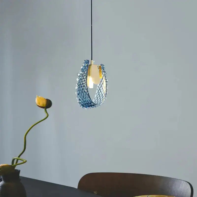 Textured turquoise blue glass luxury wall sconce with delicate chain design and gold-toned accents by decorbites blue glass