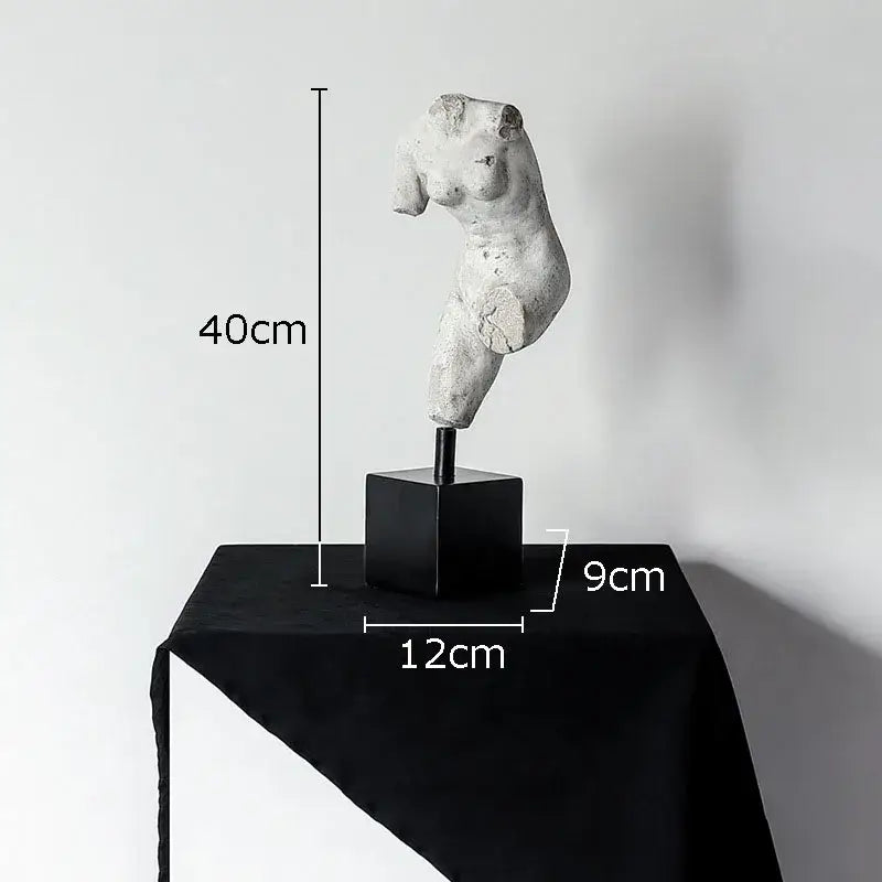 A weathered white body art resin sculpture of a female torso on a black base by decorbites for living room decor