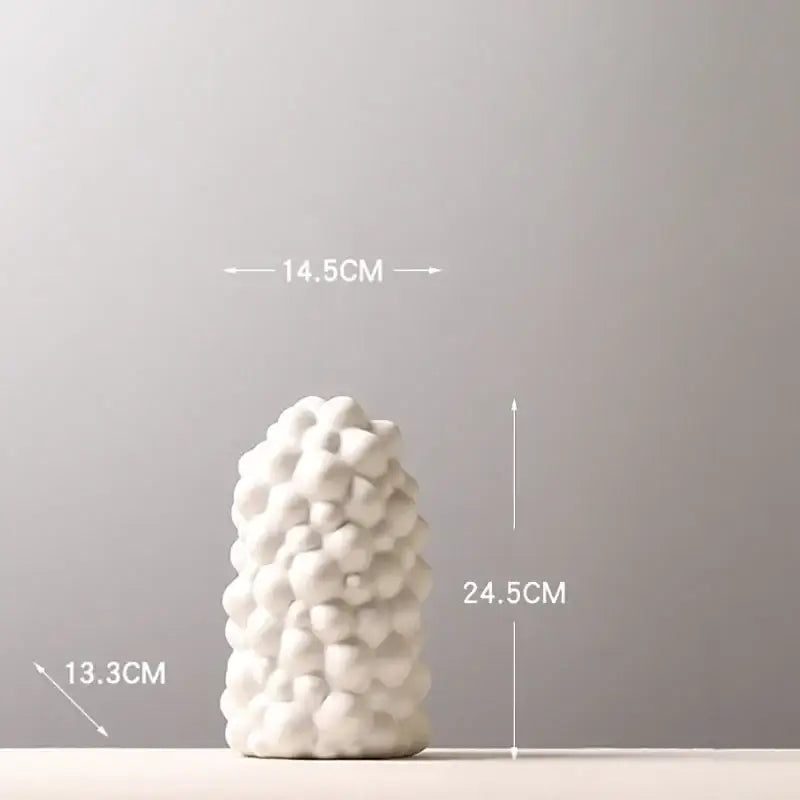 White ceramic vase set with textured bubble-like surface and artificial flowers for living room decor
