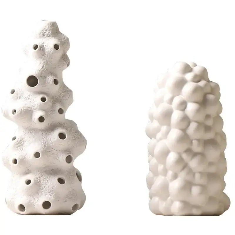 White ceramic vase set with textured organic forms featuring artificial flowers for living room decor