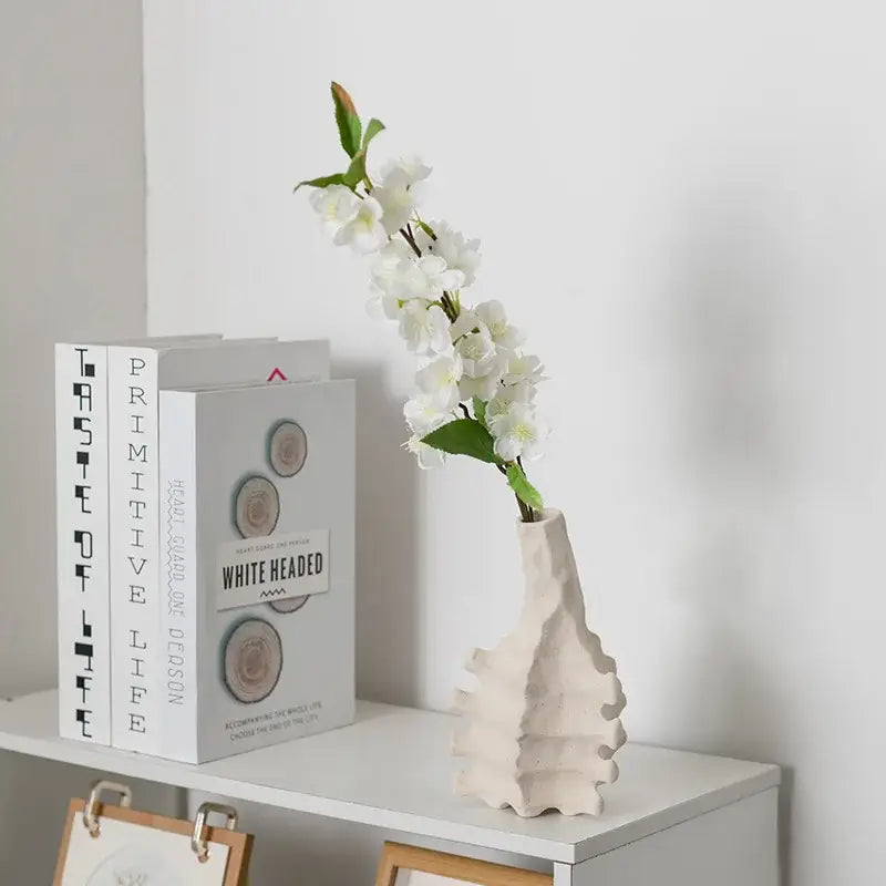 Beige decorbites ceramic vase with textured geometric design holding white artificial flowers for home decor