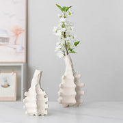 White ceramic decorbites ceramic vase with textured segmented design and narrow neck holding white blossoms for home decor
