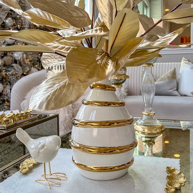 Textured white and golden ceramic vase with gold metallic bands and matching golden leaf decorbites golden ceramic decor