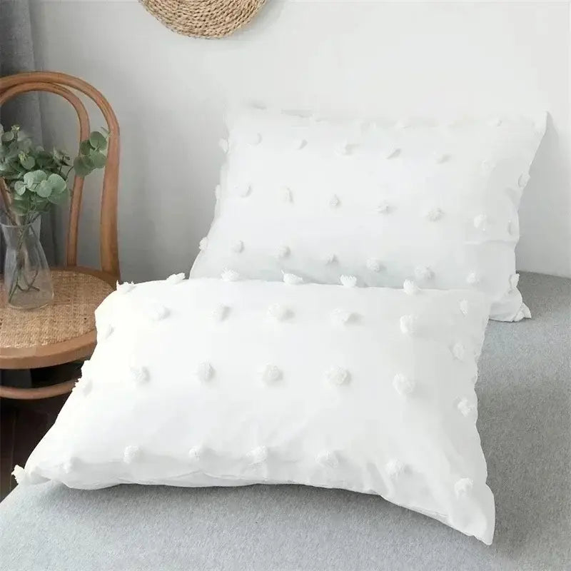 White pillow with soft textured fabric and pom pom embellishments in textured white pom pom quilt cover set for bedroom bedding