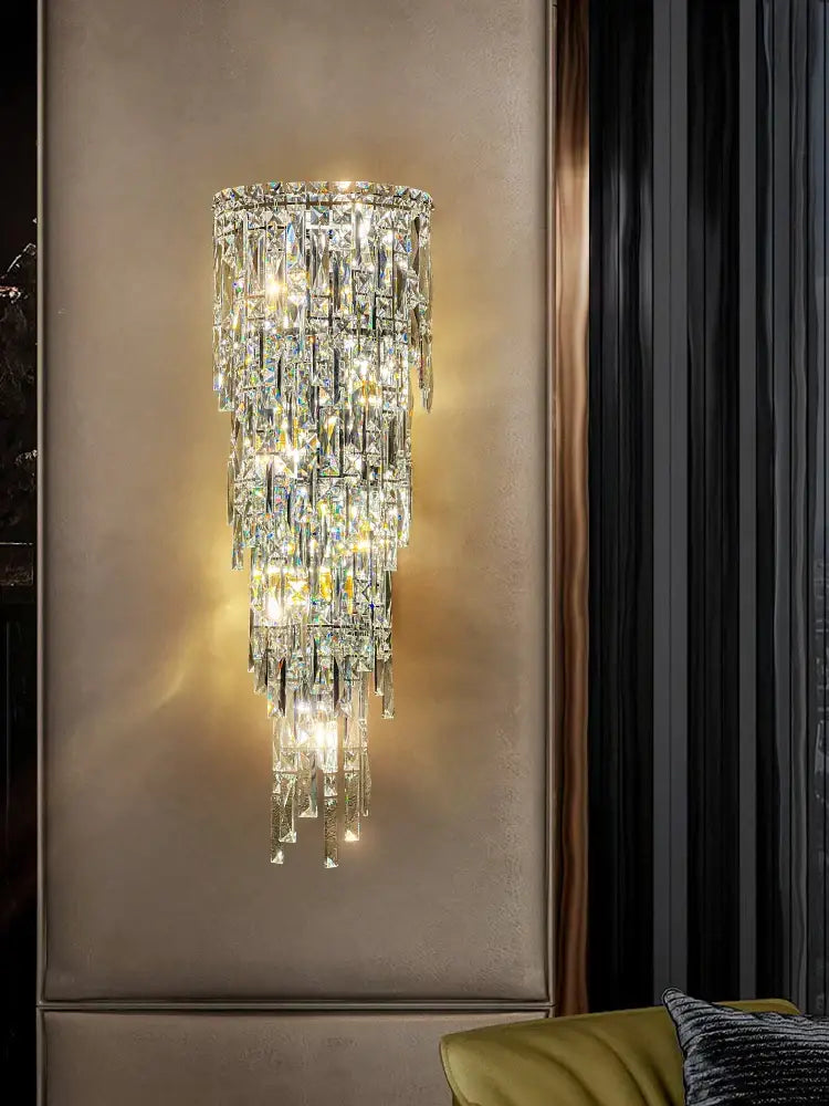 Tiered cascading crystal wall light with faceted glass elements refracting warm light for luxury living room decorbites crystal wall