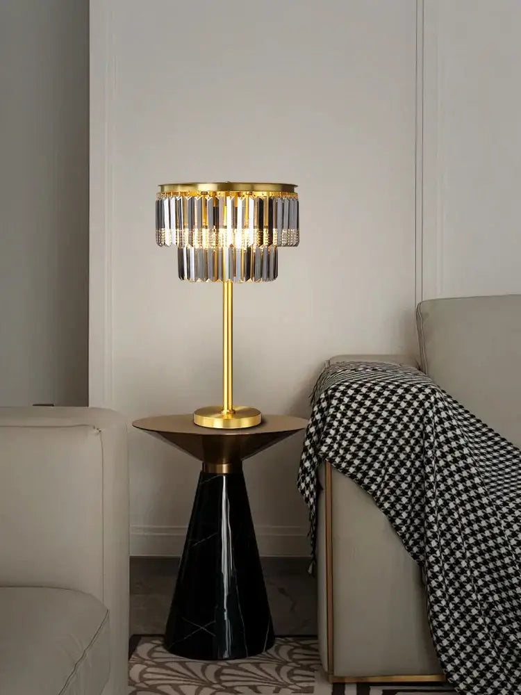 Gold-toned crystal table lamp with clear and smoked prisms on black marble base for bedroom nightstand decorbites crystal table