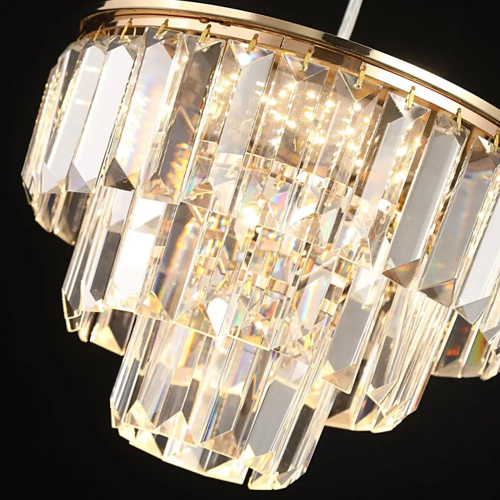 Tiered gold crystal led pendant light with faceted clear glass prisms and polished metal frame for dining room decorbites crystal led