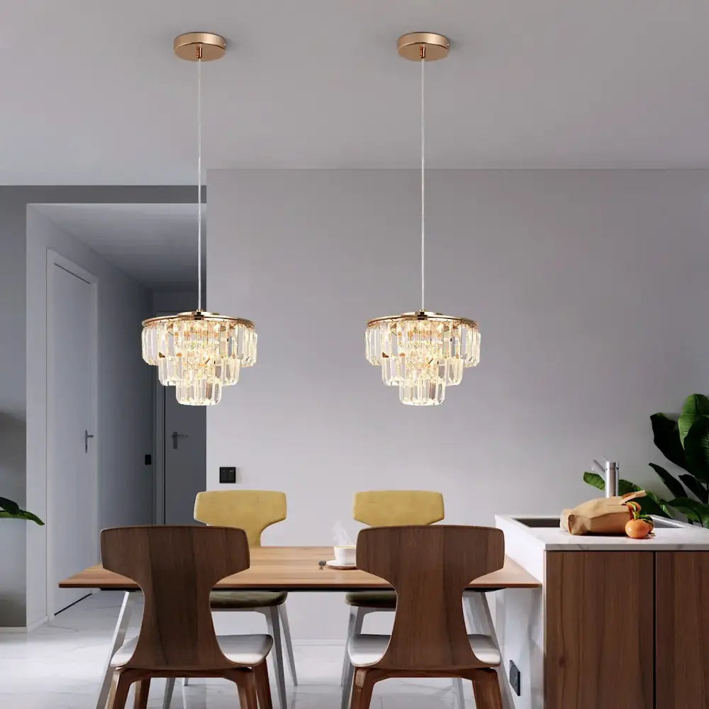 Two elegant gold-toned tiered crystal led pendant lights hang from the ceiling ideal for dining room decorbites crystal led