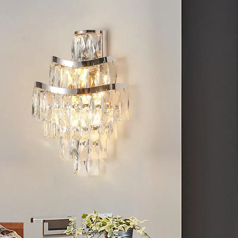 A tiered gold crystal wall lamp featuring layered chrome frames and cascading prisms for elegant decorbites crystal wall use