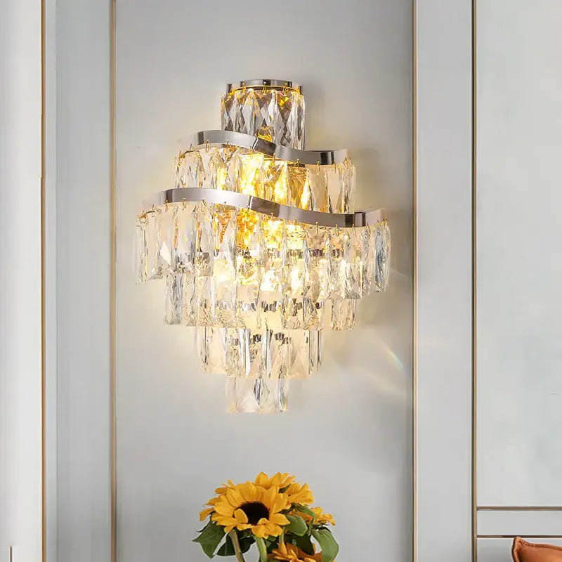 A modern tiered gold crystal wall lamp with a sleek chrome frame and faceted prisms for elegant decorbites decor
