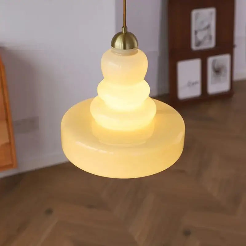 Tiered yellow glass pendant lights with brass accents featuring a warm translucent design for kitchens ceiling lighting