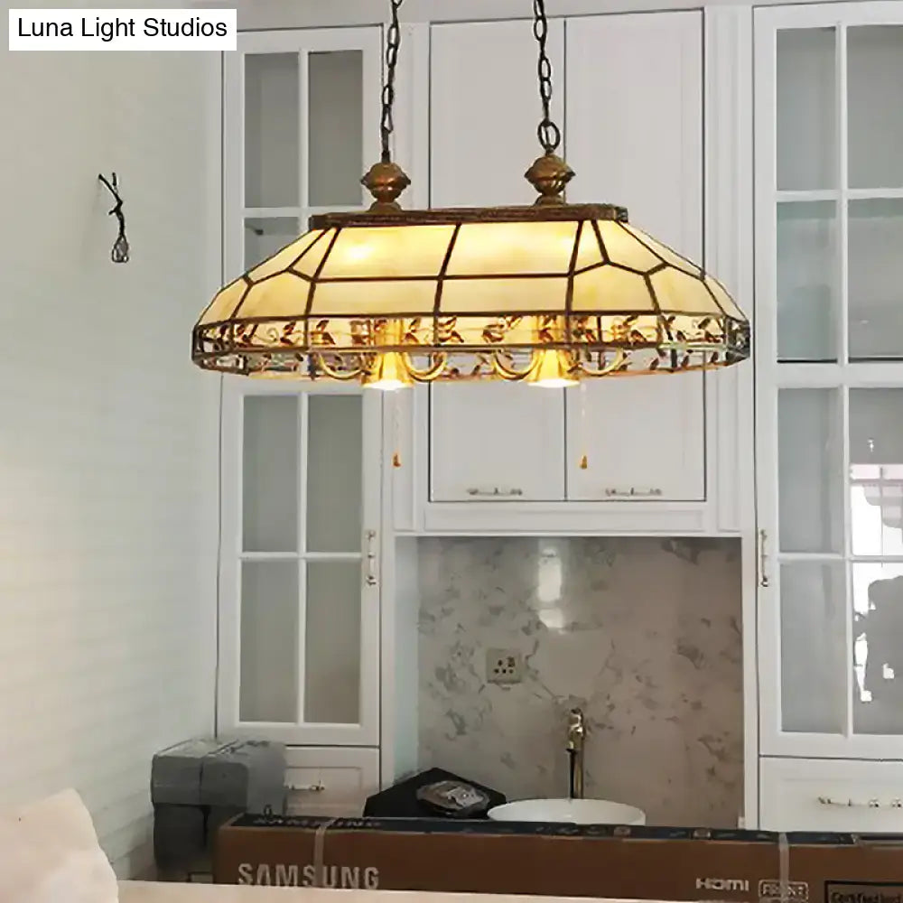Antique-style stained glass pendant light with brass frame and warm amber panels for restaurant island lighting