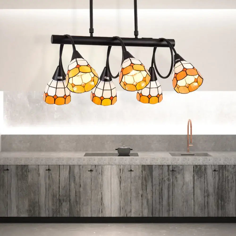 Stained glass pendant light with amber and cream hexagonal panels suspended from black metal bar for kitchen island lighting