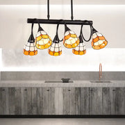 Stained glass pendant light with amber and cream hexagonal panels suspended from black metal bar for kitchen island lighting