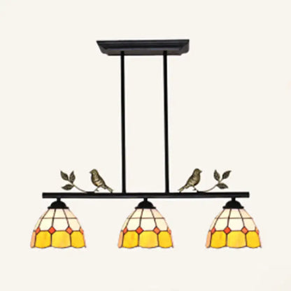 Black metal pendant light with three yellow cream stained glass shades and bird accents in black antique brass finish