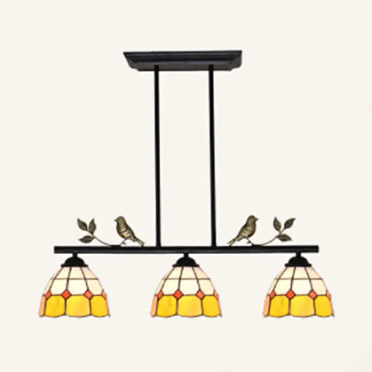 Black metal pendant light with three yellow cream stained glass shades and bird accents in black antique brass finish