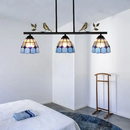 Three-light tiffany-style pendant light fixture with blue stained glass shades and a black metal curved bird shape frame