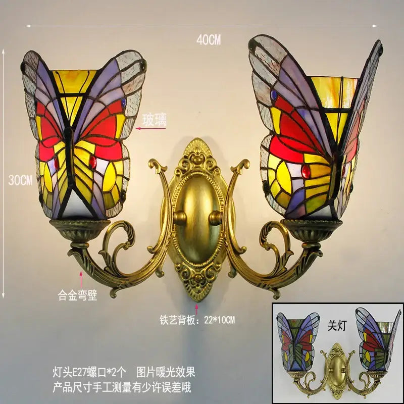 Gold-toned ornate brass wall lamps with tiffany butterfly glass sconces featuring vibrant red yellow and purple shades