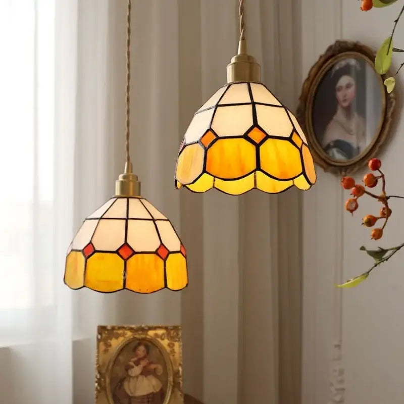 Two vintage-style tiffany glass led pendant lamps with brass fixtures in warm yellow cream hexagonal patterns for dining room