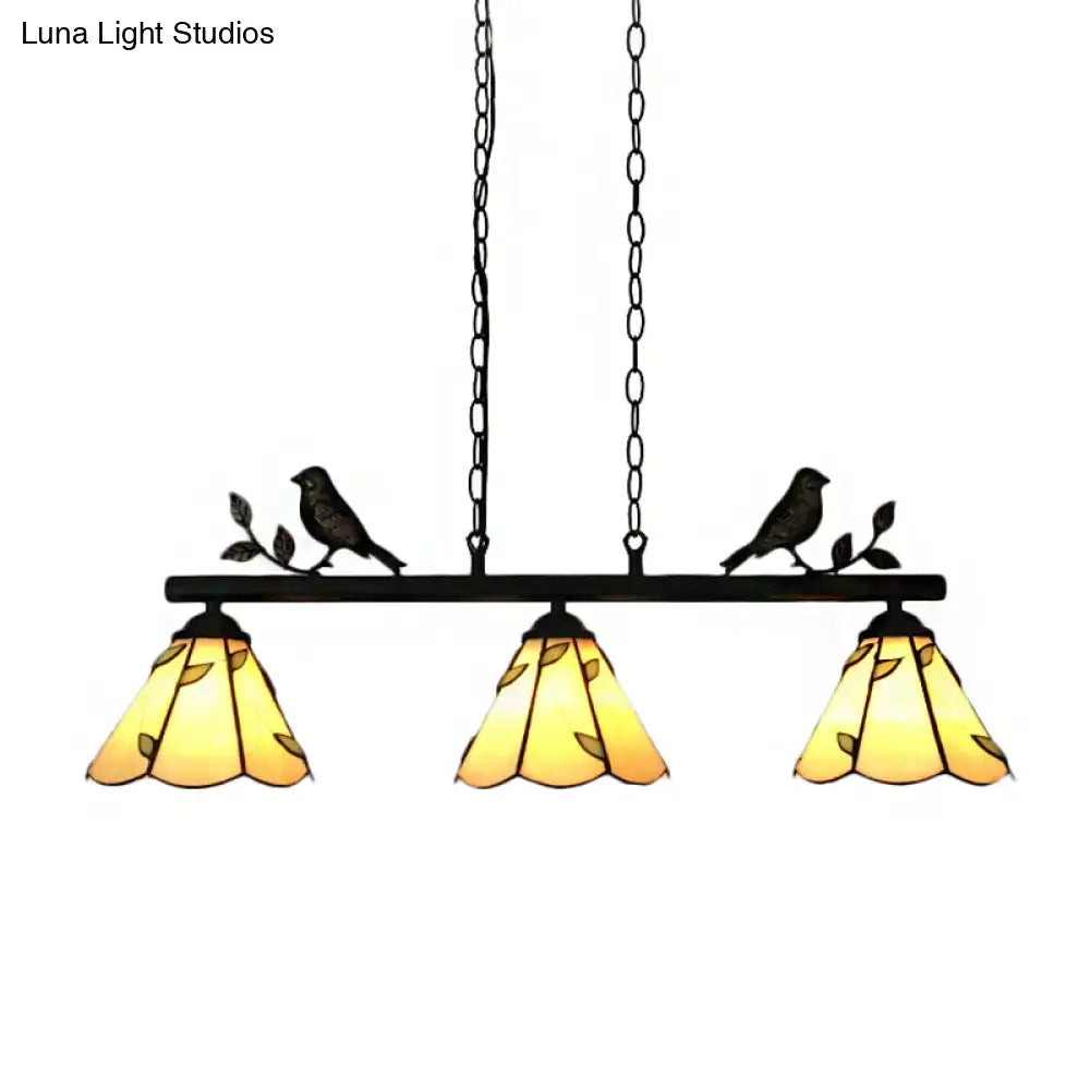 Black wrought iron pendant light with three amber cone stainless glass shades and bird accent for island lighting