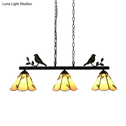 Black wrought iron pendant light with three amber cone stainless glass shades and bird accent for island lighting