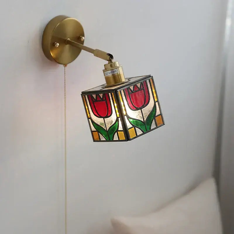 A brass-finished wall light with a colorful square glass shade featuring red tulips for bedroom decorbites colorful square wall lights