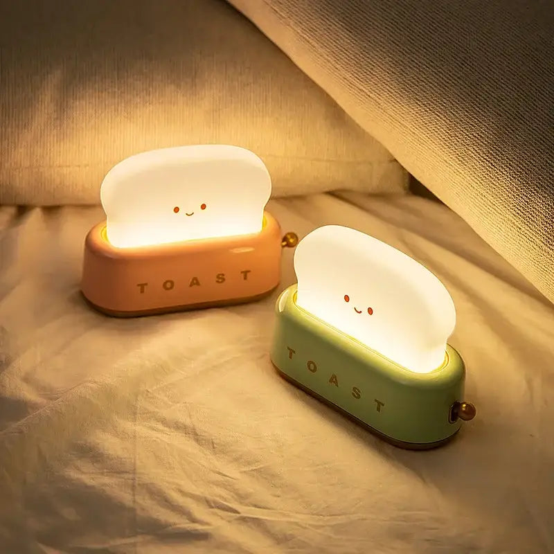 Two illuminated pastel green toast-shaped maker night lights with smiling faces and usb for bedroom use