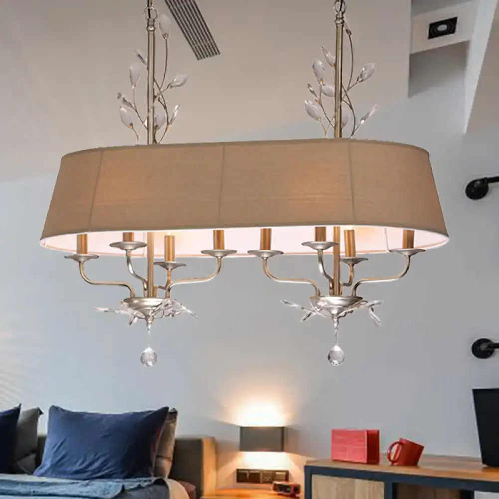 Traditional beige fabric crystal chandelier with silver metal arms and crystal droplets for dining room island lighting