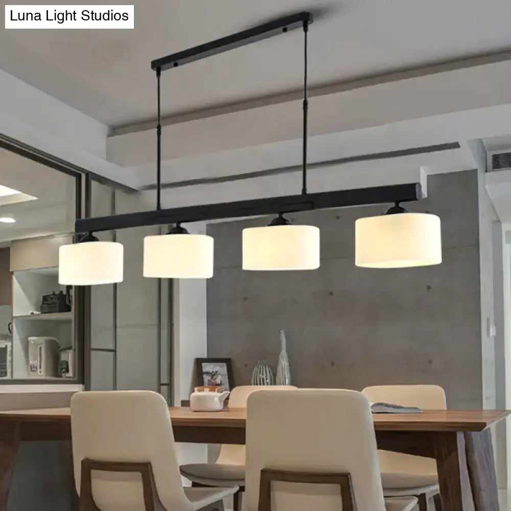 Black metal 4-light traditional drum island pendant with white cylindrical fabric shades for dining room lighting