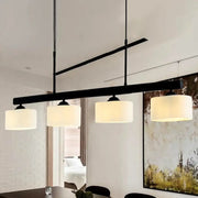 Decorbites 4-light traditional drum island pendant in black with four off-white fabric shades for dining room lighting