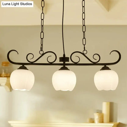 Black wrought iron DecorBites traditional island lighting fixture with three frosted glass globe shades for dining room