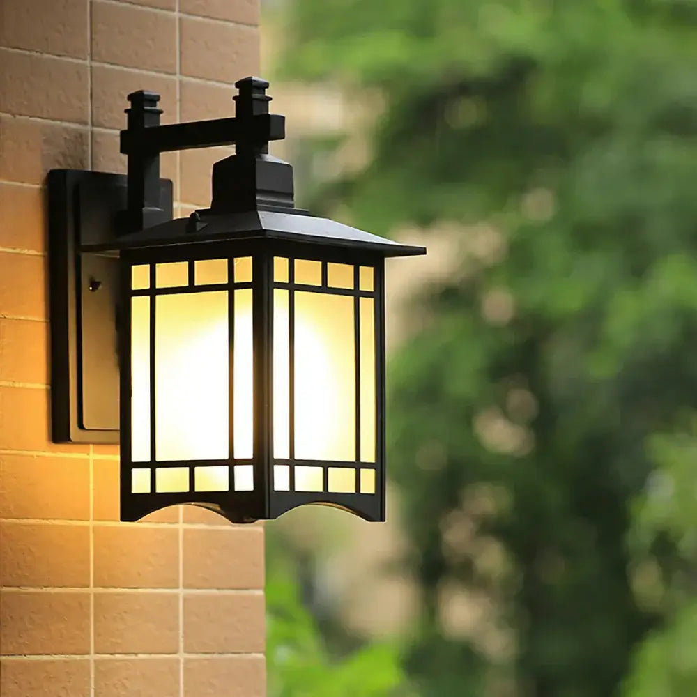 Traditional black wrought iron led wall lamp with warm yellow glass panels and ornate roof for outdoor use