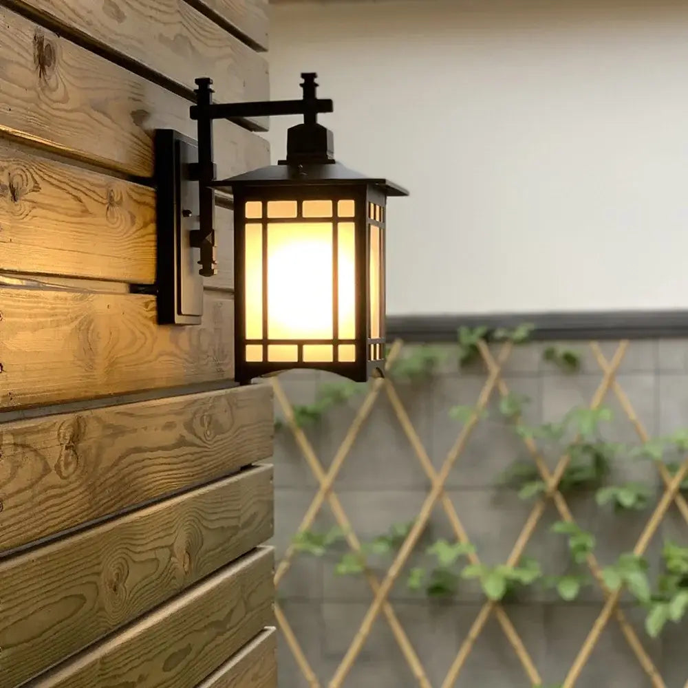 Traditional black led wall lamp garden lantern made of wrought iron with geometric frosted glass panels and warm light