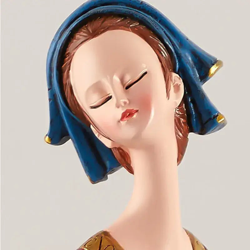 A serene resin ornament of a woman with reddish brown hair in a blue hood with gold trim for cute girls storage