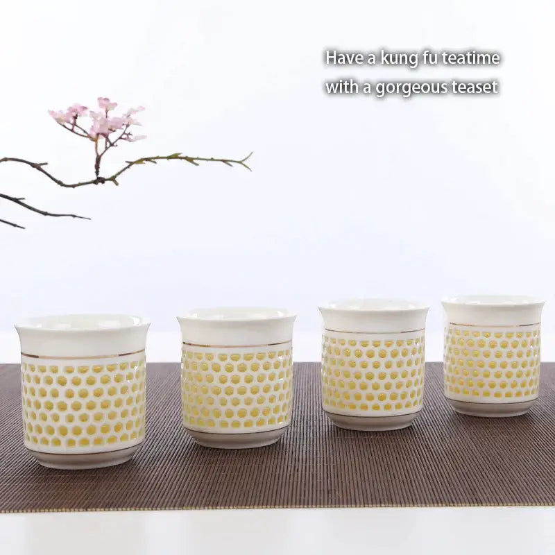 Set of four white ceramic teacups with yellow dot pattern and gold rims featured with decorbites blue white porcelain tea pot