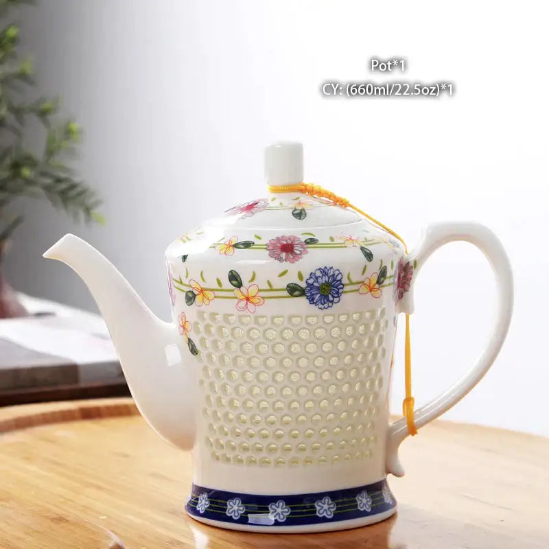 A white porcelain tea teapot with a perforated body floral pattern and yellow cord from blue white porcelain set