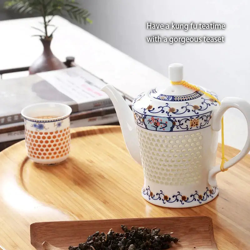 White porcelain tea teapot with blue white porcelain floral patterns and textured perforated body with yellow cord lid
