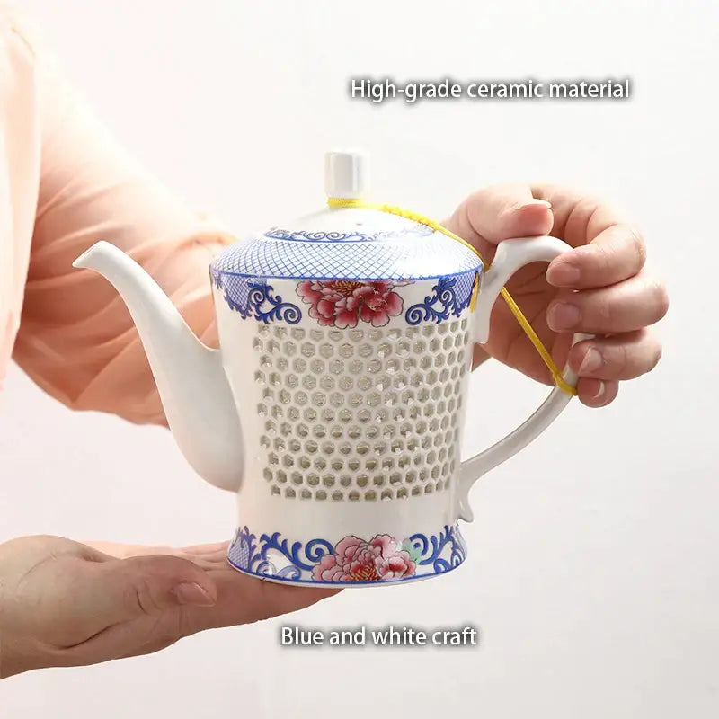 A white porcelain tea set with blue white porcelain floral patterns and perforated body for infusing tea decorbites blue white