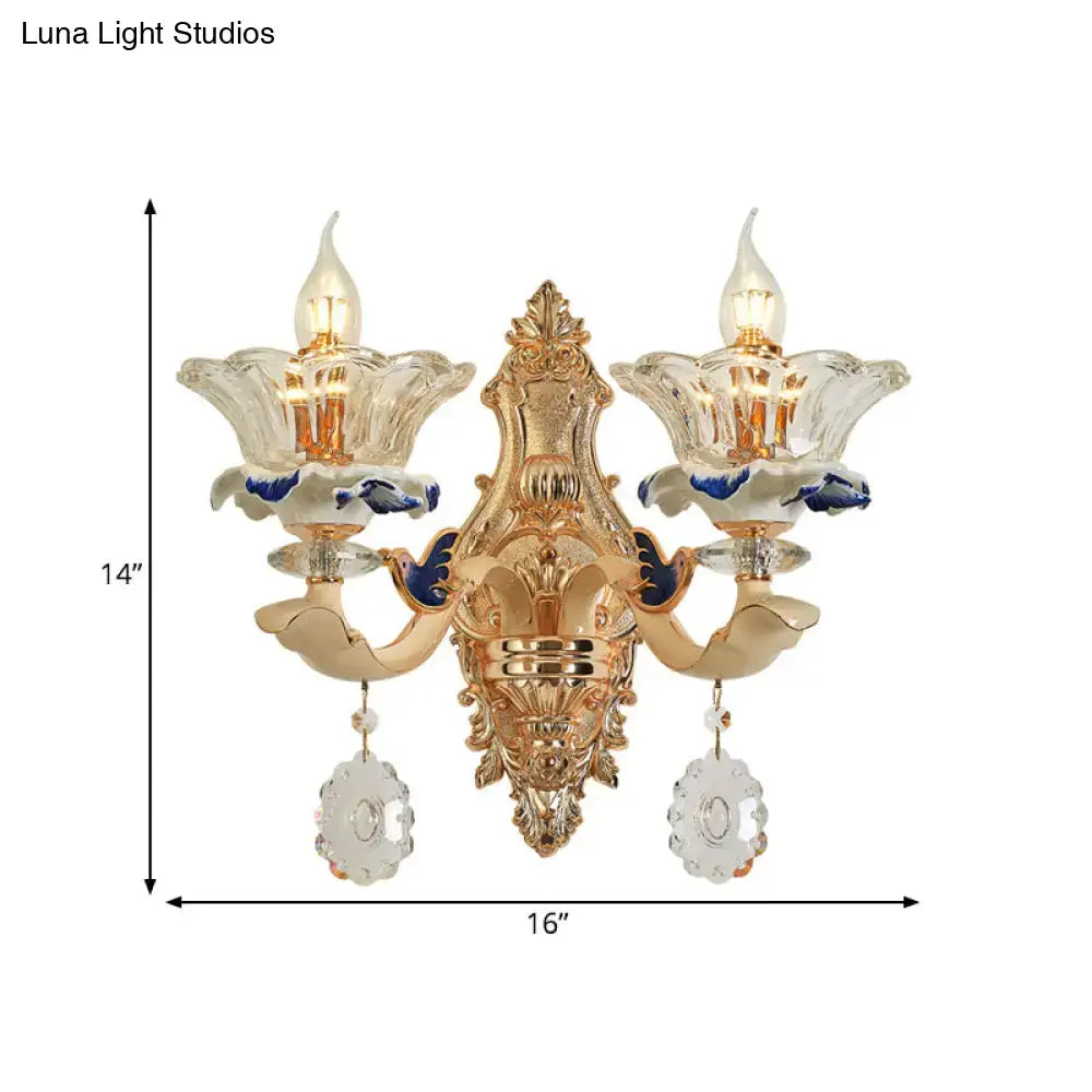 Traditional brass wall sconce light with gold-toned ornate design and crystal flower shades for living room use