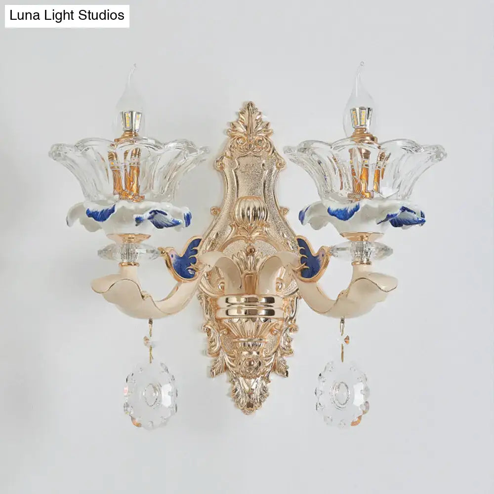 Traditional brass wall sconce light with gold finish, crystal flower-shaped shades, blue accents for living room use
