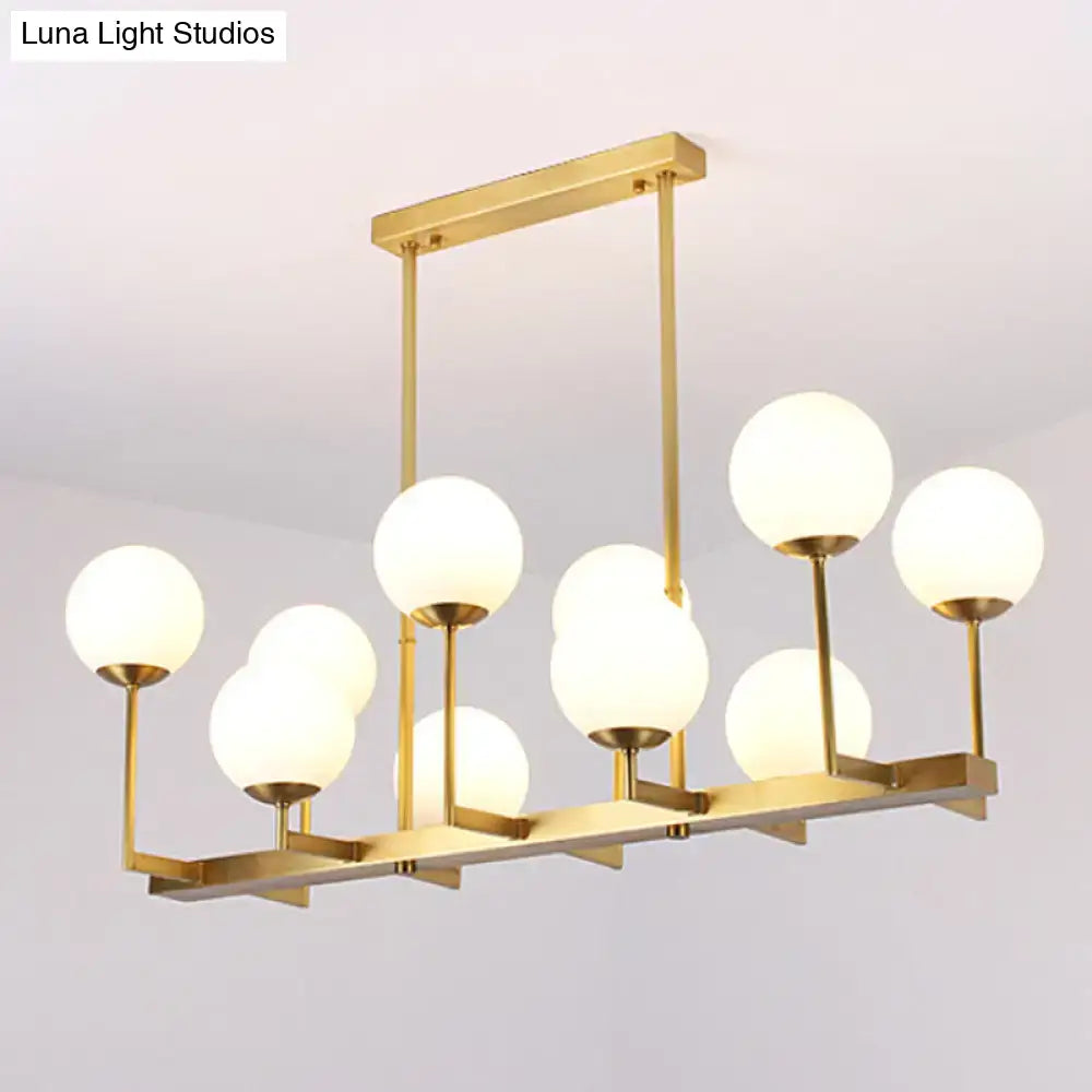 Gold-toned DecorBites opal glass island pendant light with 10 frosted globe bulbs for traditional dining room use