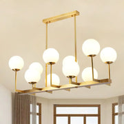 Modern gold-toned DecorBites opal glass island pendant light with 10 frosted globe lights for dining room