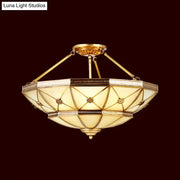 Gold-toned semi-flush mount fixture with geometric stained glass and brass accents 23.5 to 32 inch width 220v-240v