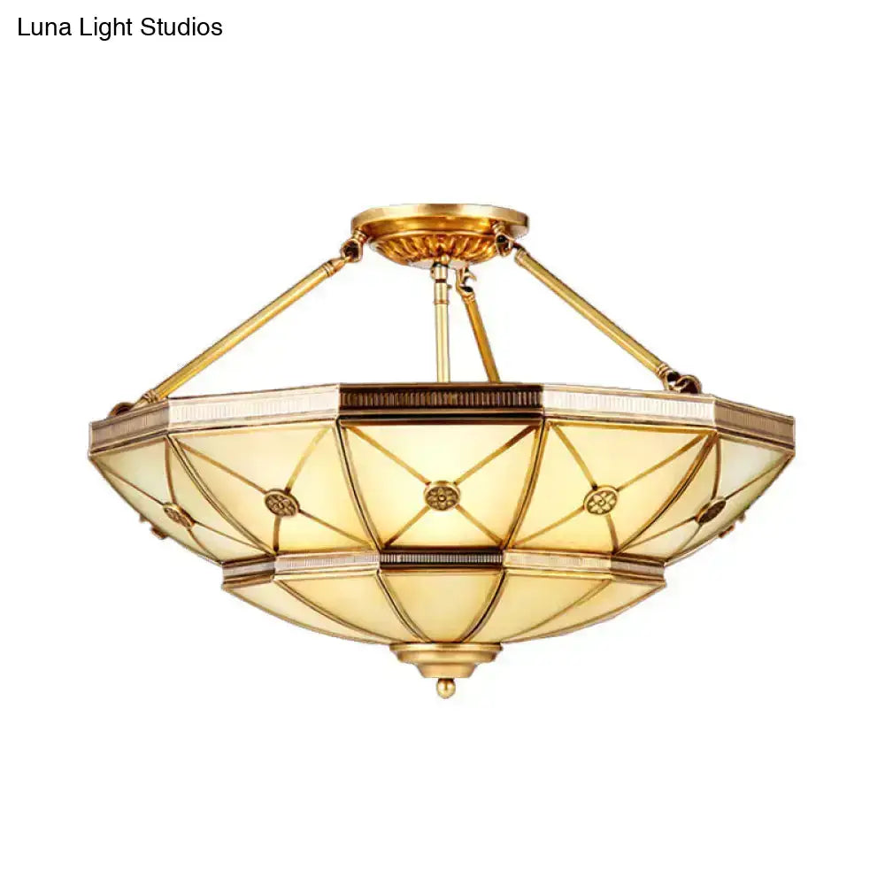 Gold-toned brass semi-flush mount fixture with 23.5 inch width and geometric amber stained glass shade for 220v-240v use